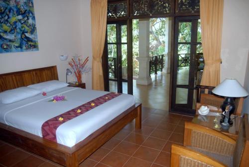 una camera con letto e tavolo con lampada di Jungle Garden Villa a Mayong