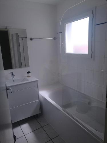 une salle de bain blanche avec une baignoire et un lavabo dans l'établissement Thalassa T3 Les Sables d'Olonne, à Les Sables-dʼOlonne