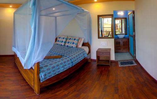 a bedroom with a bed with a canopy at Sea Front Beach Huts in Patnem