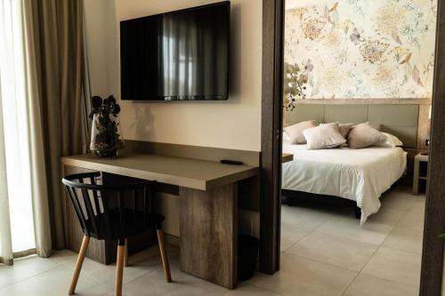 a bedroom with a bed and a desk with a mirror at Hotel Pontemare in Palermo