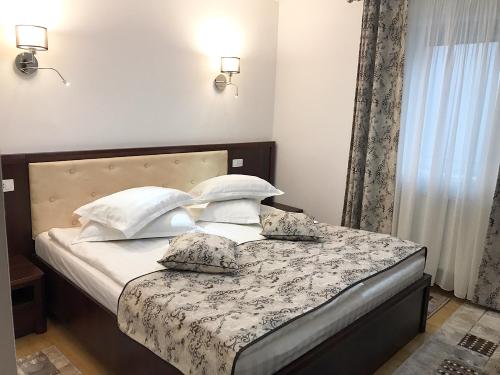 a bedroom with a bed with white sheets and pillows at Casa Pino in Braşov