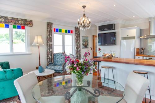 una sala de estar con una mesa de cristal con flores. en Villa Walton Bed & Breakfast, en Matamata