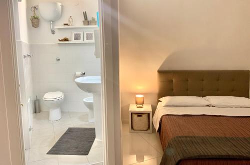 Baño pequeño con cama y aseo en CasaMamy Pompei, en Pompeya