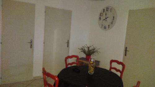 een eetkamer met een tafel en een klok aan de muur bij LE RESPECHAT in Saint-Christol-lès-Alès