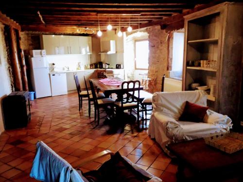 a kitchen and a living room with a table and chairs at Ker Carlines in Targassonne