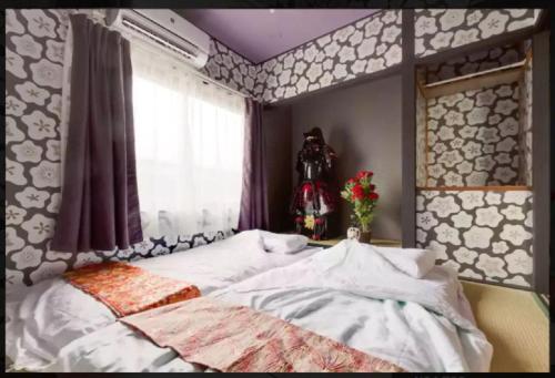 - une chambre avec un lit, une fenêtre et un vase de fleurs dans l'établissement 中川西 地下鉄今里駅一戸建 Samurai House Guest House Imazato 難波直通 最大7名, à Osaka