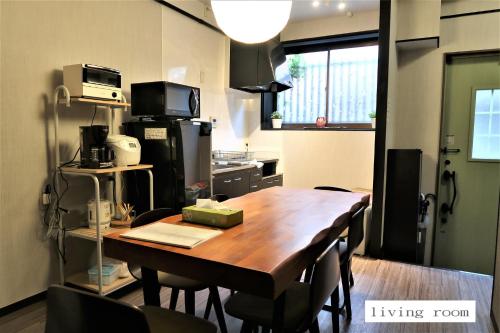 une pièce avec une table en bois et une cuisine dans l'établissement 中川西 地下鉄今里駅一戸建 Samurai House Guest House Imazato 難波直通 最大7名, à Osaka