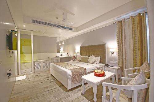 Habitación de hotel con cama, mesa y sillas en Hotel Emerald, en Chandīgarh