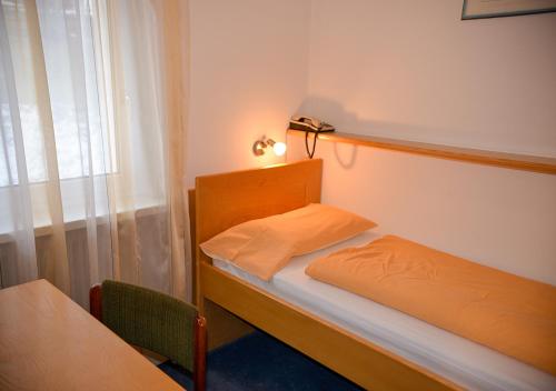 a small bedroom with a bed and a window at Hotel Regina Delle Dolomiti in Panchia