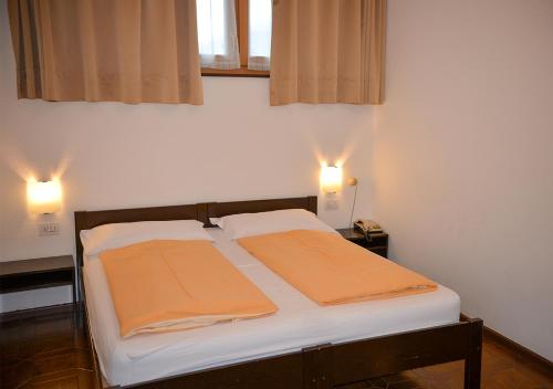 a bed with two towels on it in a room at Hotel Regina Delle Dolomiti in Panchia