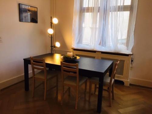 a dining room with a table and chairs and a window at Apartment Marktplatz in Basel