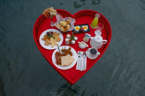 Una bandeja en forma de corazón con alimentos para el desayuno. en BE Grand Resort, Bohol, en Panglao