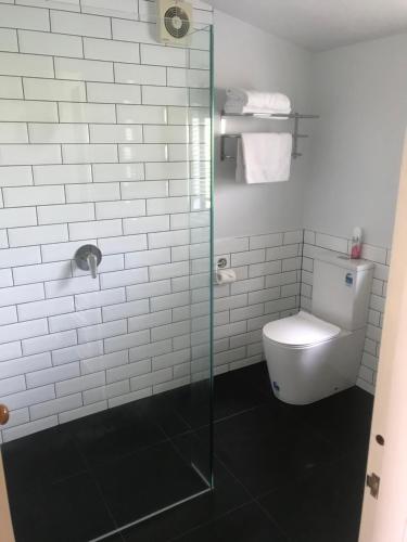 a bathroom with a toilet and a glass shower at Pinot Villas in Martinborough 