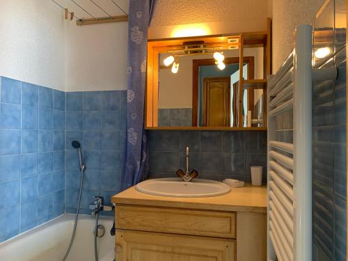 La salle de bains est pourvue d'un lavabo, d'une baignoire et d'un miroir. dans l'établissement Le Kodiac, au Grand-Bornand