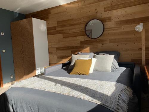 - une chambre avec un lit et un mur en bois dans l'établissement Le Kodiac, au Grand-Bornand