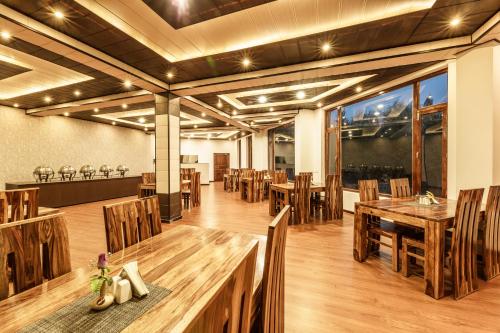 een eetkamer met houten tafels en stoelen bij Hotel Asia in Leh