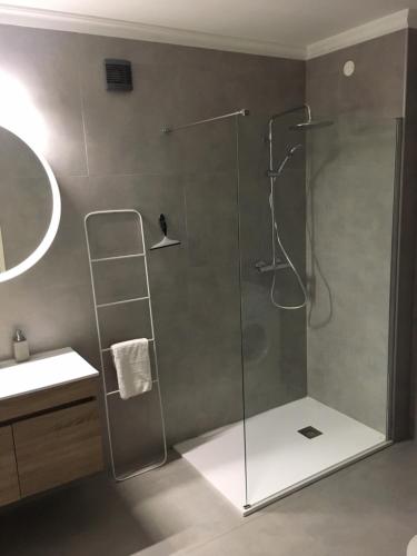 een douche met een glazen deur in een badkamer bij Lagos Beach 59A in Lagos