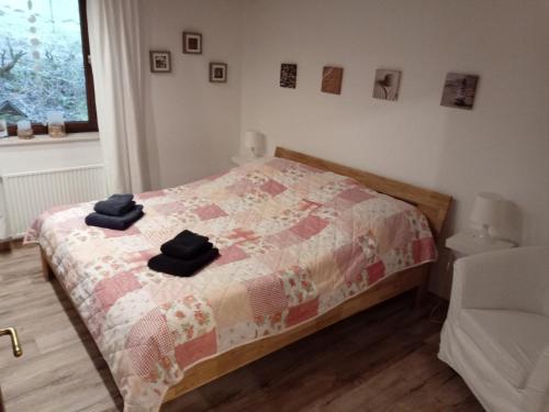 a bedroom with a bed with two black towels on it at Ferienwohnung Schmallenberg in Schmallenberg