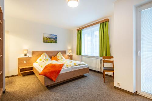 a hotel room with a bed and a window at Haus Sonja - inklusive Eintritt in die Alpentherme Gastein in Bad Hofgastein