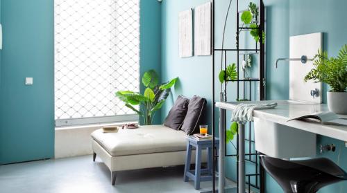 a blue room with a white chair and plants at ALTIDO Stylish 5BR Apt with big terrace in Principe Real in Lisbon