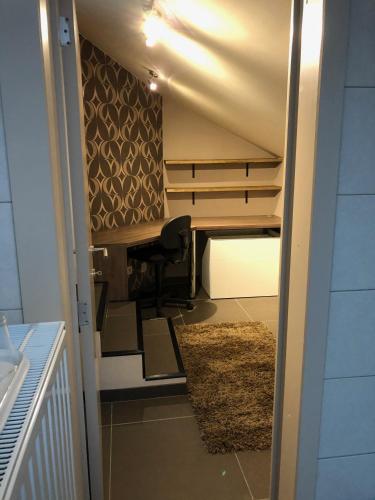 a room with a desk and a chair and a rug at Gastenverblijf 't Princenhuis in Vechmaal