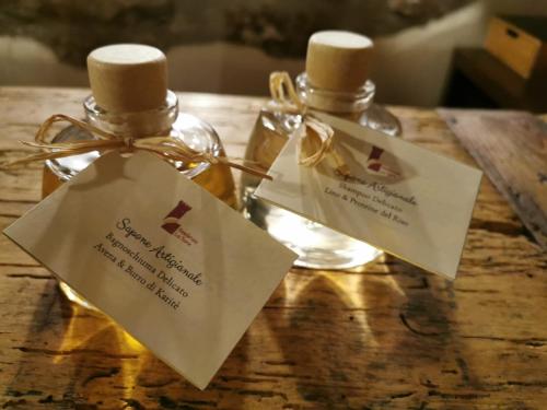 two bottles of essential oils sitting on a wooden table at Residenza La Torre in Santo Stefano di Sessanio