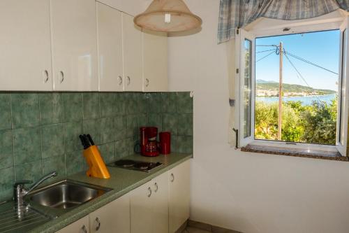 a kitchen with a sink and a window at Apartments Anita 2 in Rab
