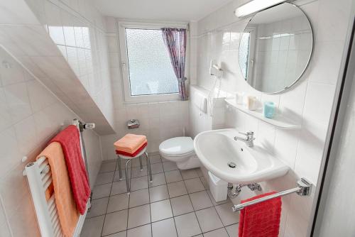 Baño blanco con lavabo y aseo en Haus Dünenglück Whg. 34, en Cuxhaven
