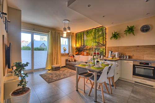 een keuken en een woonkamer met een tafel en stoelen bij Apartament Diamentowy in Lesko