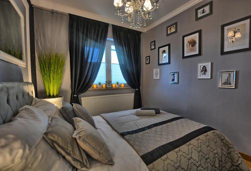 a bedroom with a bed with a chandelier and a window at Apartament Diamentowy in Lesko
