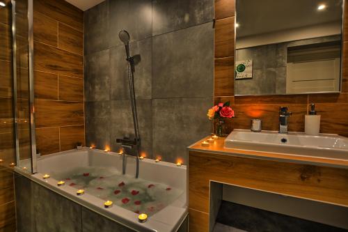 La salle de bains est pourvue d'une baignoire et d'un lavabo éclairé. dans l'établissement Apartament Diamentowy, à Lesko