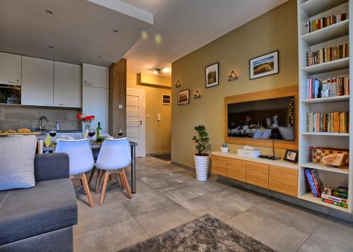 een woonkamer met een bank, een tafel en een televisie bij Apartament Diamentowy in Lesko
