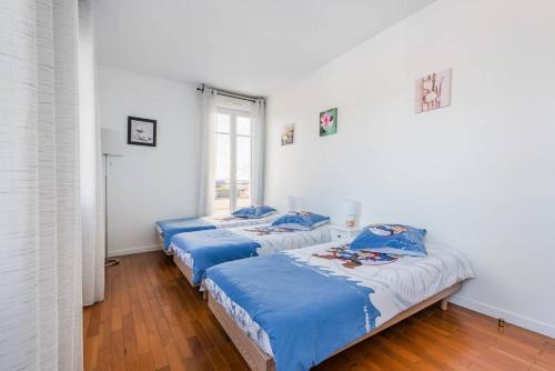 two beds in a room with a window at Smart apartment Val d'Europe 7/9 pers in Chessy