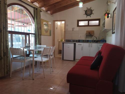 un salon avec une table et un canapé rouge dans l'établissement Lotus turtle garden Eilat, à Eilat