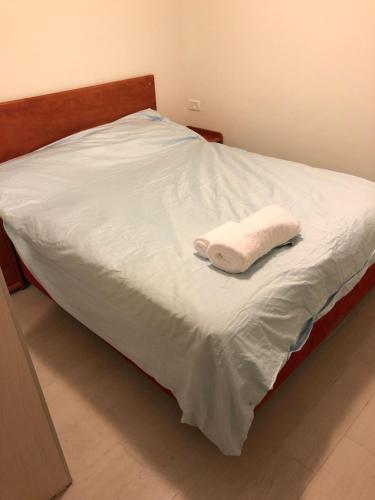 a bed with a white towel on top of it at Buchman apartment near center in Modi‘in