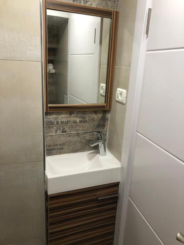 W łazience znajduje się umywalka i lustro. w obiekcie Buchman apartment near center w mieście Modi‘in
