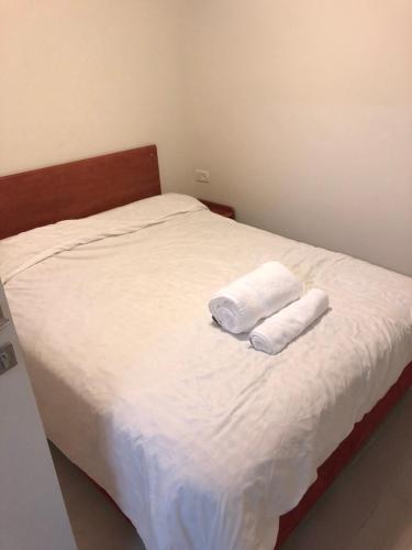 a bed with two towels on top of it at Buchman apartment near center in Modi‘in