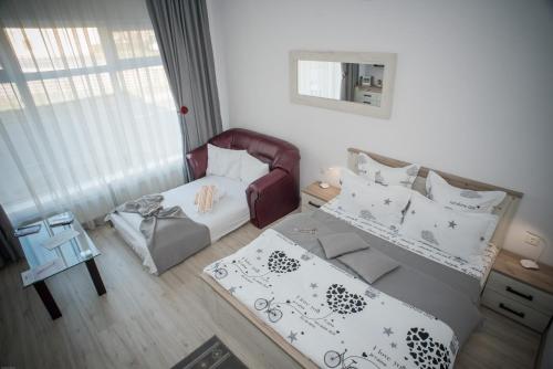 Habitación con silla, cama y mesa. en Apartament LA MAL en Sibiu