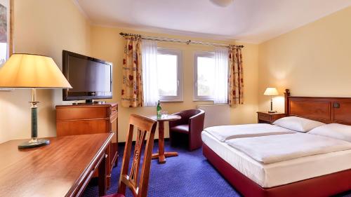 a hotel room with a bed and a desk at Dorint MARC AUREL Spa & Golf Resort in Bad Gögging