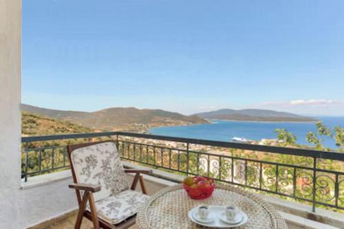 a balcony with a table and a chair and the ocean at Marmari View in Marmarion