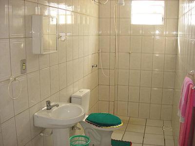 Baño blanco con lavabo y aseo en Pousada Serafin Azul, en Florianópolis