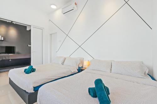two beds in a room with blue towels on them at Puchong Skypod Residence, 1-5 pax with Balcony Unit, Walking Distance to IOI Mall, 10min Drive to Sunway in Puchong