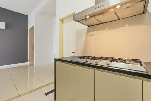 a kitchen with a stove and a counter top at Puchong Skypod Residence, 1-5 pax with Balcony Unit, Walking Distance to IOI Mall, 10min Drive to Sunway in Puchong