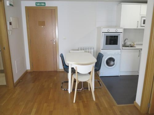 a small kitchen with a table and a washing machine at Tudela balcón de Bardenas in Tudela