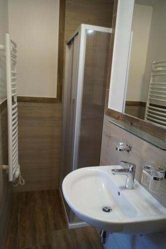 a bathroom with a white sink and a shower at Pension Anneliese in Rauris