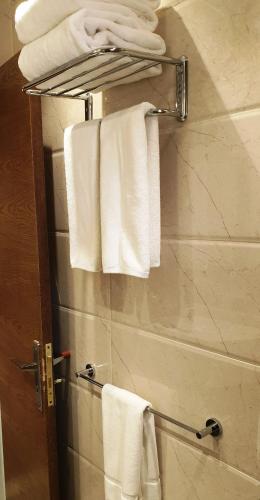 a bathroom with white towels hanging on a towel rack at Swiss Flora Inn Hotel Riyadh in Riyadh