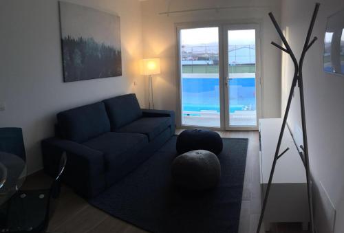 sala de estar con sofá azul y ventana en Blanco 35 by SunHousesCanarias, en El Tablero
