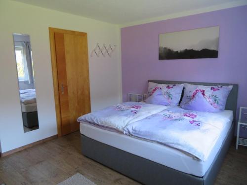 Schlafzimmer mit einem Bett mit weißer Bettwäsche und rosa Kissen in der Unterkunft Appartement Reiter in Aschau