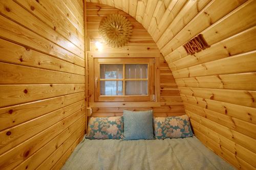 Glamping Turquesa, feel and relax in a wood house في Corredoura: سرير في كابينة خشب مع نافذة