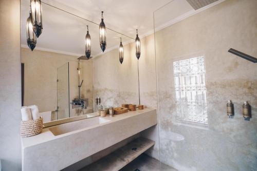 un bagno con lavandino e specchio di Riad Bamboo Suites & Spa a Marrakech